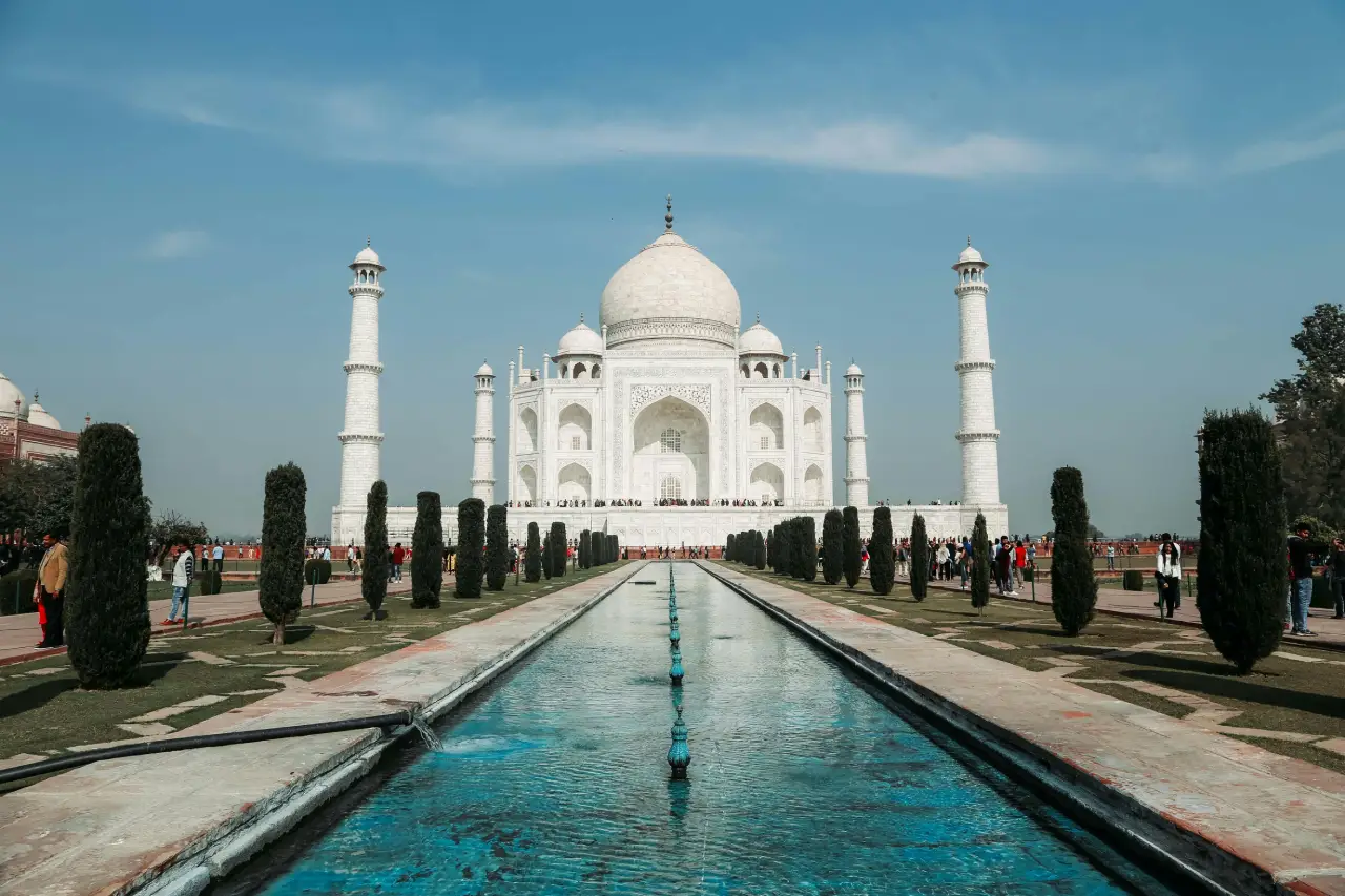 Panoramic front view of the Taj Mahal with reflecting pool and gardens, used as the About Us banner image on Atulya Voyages.